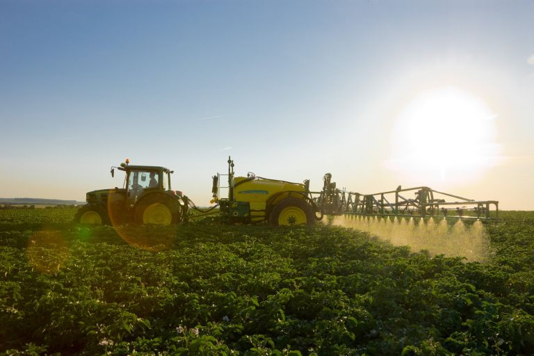 Boerenbond tractor fertilizes the field 